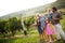 Happy wine grower family walking in vineyard