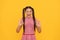 Happy winking girl child show double ring gesture yellow background, OK