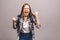 Happy winner! Close-up of emotional young attractive woman with keeping hands in fists, isolated on grey background. Surprised