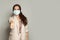 Happy woman in anti virus protection mask to prevent others from corona COVID-19 holding thumb up on gray banner background