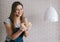 Happy woman baker knead dough lump against the background of a brick wall and the white lamp