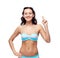 Happy woman in bikini swimsuit pointing finger up