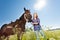 Happy woman with brown stallion in countryside