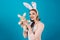 Happy woman in bunny ears with toy. Spring holiday. Girl with hare toy. Egg hunt. Easter eggs as traditional food. Happy