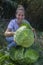 Happy woman with a cabbage in hands smiling.Harvesting in vegetable garden lifestyle concept.Organic healthy food