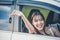 Happy woman with car key sitting and smiling in modern auto outdoors on sunny day. Woman driver holding car keys driving her new