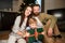 Happy woman celebrating New Year with son and husband in decorated hotel setting