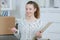 Happy woman checking office relocation list on clipboard