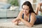 Happy woman checking smartwatch on a carpet