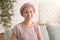 Happy woman after chemotherapy  sitting on sofa at home