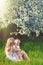 Happy woman and child in the blooming spring garden