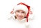 Happy woman with christmas hat peeking through a hole torn in white paper poster