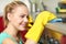 Happy woman cleaning cooker at home kitchen