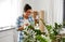 Happy woman cleaning houseplant at home