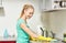 Happy woman cleaning table at home kitchen