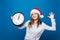 Happy Woman with clock shows 12 oclock New Year party begin on blue background