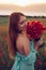 Happy woman with closed eyes holding bouquet of poppies