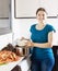 Happy woman cooking paella