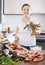 Happy woman cooking paella with seafood