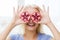 Happy woman covering eyes with pomegranate
