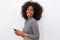 Happy woman with curly hair holding mobile phone