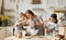 Happy woman and cute children cooking together in kitchen