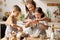 Happy woman and cute children cooking together in kitchen