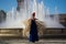 The happy woman dancing flamenco near the fountain