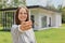 Happy woman with dark hair showing keys of new home looking smiling at camera real estate agent buying new big house wearing