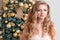 Happy woman on decorated golden Christmas tree background. Luxury blonde girl. Merry Christmas and Happy New Year celebration them