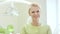 Happy woman dentist standing in dental office. Blonde nurse smiling on camera