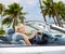 Happy woman driving convertible car over beach