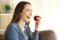 Happy woman eating an apple looking away