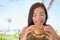 Happy Woman Eating Burger Sandwich At Beach