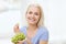 Happy woman eating grapes at home