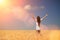 Happy woman enjoying the life in the field Nature beauty, blue cloudy sky and colorful field with golden wheat. Outdoor lifestyle.