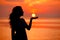 Happy Woman enjoying in Sea Sunset. Silhouetted against the suns