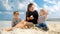 A happy woman enjoys a beach picnic with her two sons, eating fresh fruits and feeling joy. Family vacation and weekend on nature