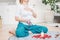 Happy woman in ethnic costume practicing yoga in front of candles and red rose petals, hands with mehendi and mala beads on the