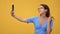 Happy woman in eyeglasses posing taking selfie use smartphone peace greeting gesture isolated