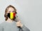 Happy woman in face mask holding thumb up with national flag Belgium. Flu epidemic and virus protection concept
