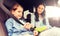 Happy woman fastening child with seat belt in car