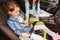 Happy woman fastening child with seat belt in car