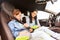 Happy woman fastening child with seat belt in car