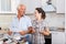 Happy woman with father discussing work manual on mixer tap
