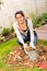 Happy woman filling bucket leaves fall gardening