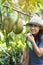 Happy woman with Fresh Durian hanging on tree in organic farm, king of fruit Thailand. Famous Southeast food, Asian Exotic