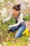 Happy woman gardening bush fall backyard kneeling