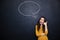 Happy woman gesturing talking on phone over blackboard background