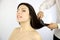 Happy woman getting long hair styled by professional coiffeur